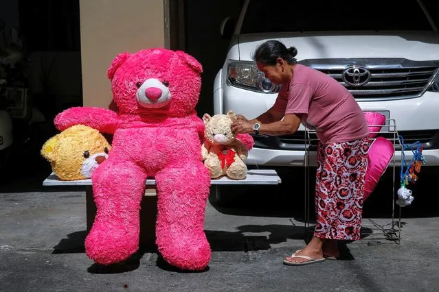 Ofel (R) sews one of her boss' teddy bears as she sets them outside to dry at their residence in Makati, Metro Manila, Philippin​es, 24 November 2021. (Photo by Mark R. Cristino/EPA/EFE)