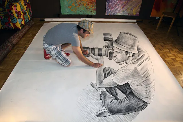 Visual artist Ben Heine at work in his studio while he creates one of his “anamorphic illusions” in Rochefort, Belgium