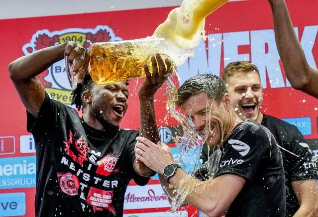 Leverkusen's head coach Xabi Alonso , centre, is sprayed with beer after Bayer Leverkusen won the German Bundesliga title beating Werder Bremen in Leverkusen, Germany, Sunday, April 14, 2024. (Photo by Martin Meissner/AP Photo)