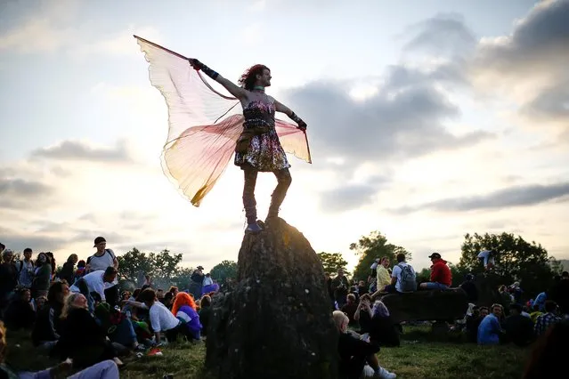 A festival goer dances during sunset at the stone circle during Glastonbury Festival at Worthy farm in Somerset, Britain on June 26, 2019. (Photo by Henry Nicholls/Reuters)