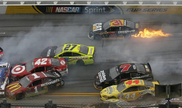 Flames trail from the car of Ryan Newman (31) after a pileup of crashed cars around the track during the NASCAR Talladega auto race at Talladega Superspeedway, Sunday, May 1, 2016, in Talladega, Ala. (Photo by Skip Williams/AP Photo)