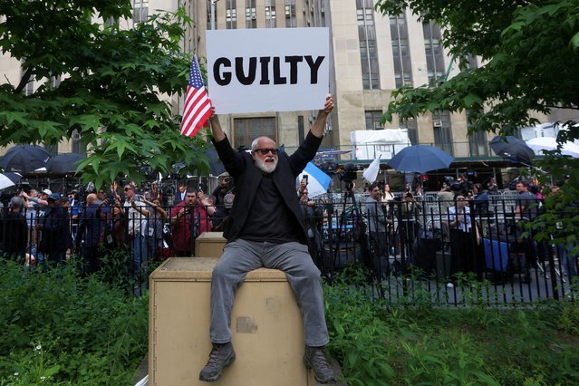 A man holds a placard outside Manhattan criminal court following the verdict in Donald Trump's criminal trial on May 30, 2024. (Photo by Mike Segar/Reuters)