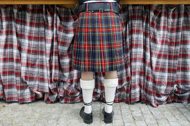 A musician from the “Pipe and Drums of Geneva” band waits to be served in front of a booth at the 34th Bernex Musical Music Meetings this Sunday, September 1, 2019 in Bernex near Geneve, Switzerland. (Photo by Salvatore Di Nolfi/Keystone)