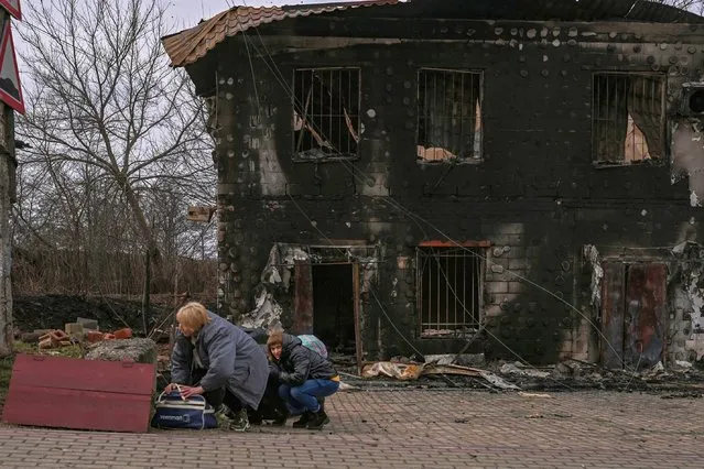 People take cover from shelling in the city of Bucha, west of Kyiv, on March 4, 2022. (Photo by Aris Messinis/AFP Photo)