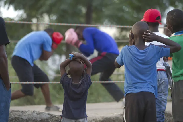 In this Sunday, March 18, 2017 photo, children follow a boxing match in Chitungwiza about 30 kilometres south east of Harare, Zimbabwe. Zimbabwean boys as young as 10 hurry every weekend to a boxing ring whose nickname, Wafa Wafa, in the local Shona language suggests that whoever enters will be lucky to come out alive. (Photo by Tsvangirayi Mukwazhi/AP Photo)