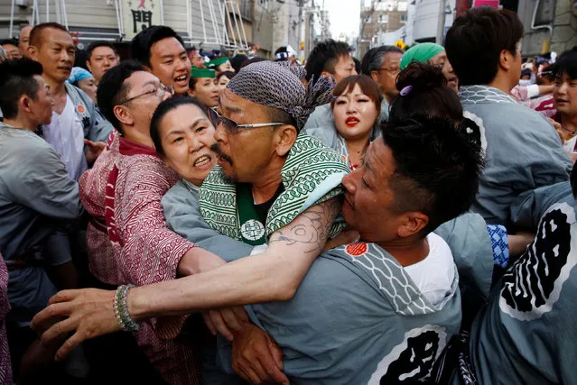 People scuffle to get close to a portable shrine that is being carried by an opposing team during the Sanja festival in Tokyo's Asakusa district, Japan, May 15, 2016. (Photo by Thomas Peter/Reuters)