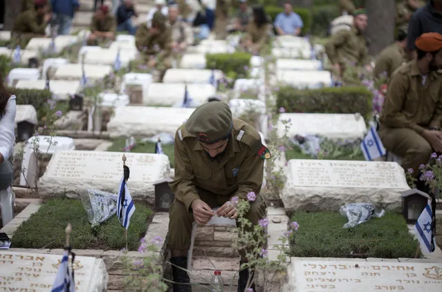 An Israeli soldier sits next to graves of a fallen soldier at the military cemeteryon May 1, 2017 in Jerusalem, Israel. Israel marks the Remembrance Day to commemorate over 25,000 fallen soldiers since 1948, just before the celebrations of the 69th Independence Day anniversary according to the Jewish calendar. (Photo by Lior Mizrahi/Getty Images)