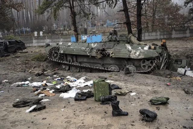 Military gear left behind by Russian soldiers lay scattered near a tank during a military sweep by Ukrainian soldiers after the Russians' withdrawal from the area on the outskirts of Kyiv, Ukraine, Friday, April 1, 2022. (Photo by Rodrigo Abd/AP Photo)