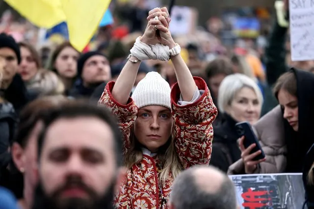 A woman shows her tied hands during a pro-Ukrainian protest, as Russia's invasion of Ukraine continues, in Berlin, Germany, April 6, 2022. (Photo by Christian Mang/Reuters)