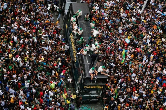 Rugby fans surround the bus of the South African Springbok rugby team, during a victory parade in downtown Johannesburg, South Africa, Thursday, November 7, 2019. South Africa's Rugby World Cup-winning team has started a five-day victory tour where they will carry the trophy across the country. (Photo by Denis Farrell/AP Photo)