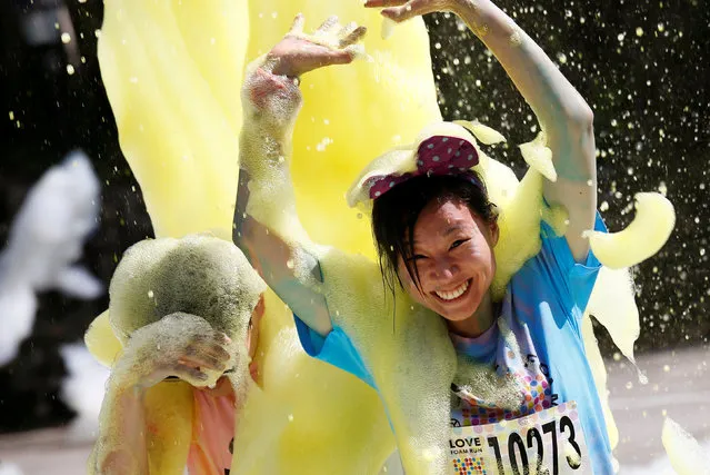 Participants run through foam during the Love Foam Run race in Hsinchu, Taiwan May 29, 2016. (Photo by Tyrone Siu/Reuters)