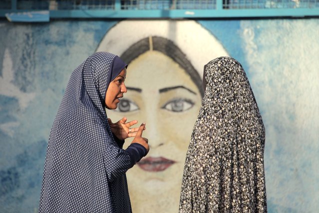 Displaced Palestinian women talk in the courtyard of an UNRWA school in which they are taking shelter in Nuseirat in the central Gaza Strip on May 17, 2024, amid the ongoing conflict between Israel and the militant group Hamas. (Photo by AFP Photo/Stringer)