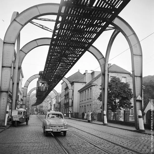 1956:  A hanging monorail train moves along the seven mile Wuppertal Monorail System in Germany, just above the stream of traffic