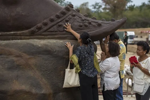 People pay their respect to a giant bronze statue of former King Ram Khamhaeng after a religious ceremony at Ratchapakdi Park in Hua Hin, Prachuap Khiri Khan province, Thailand, July 27, 2015. (Photo by Athit Perawongmetha/Reuters)