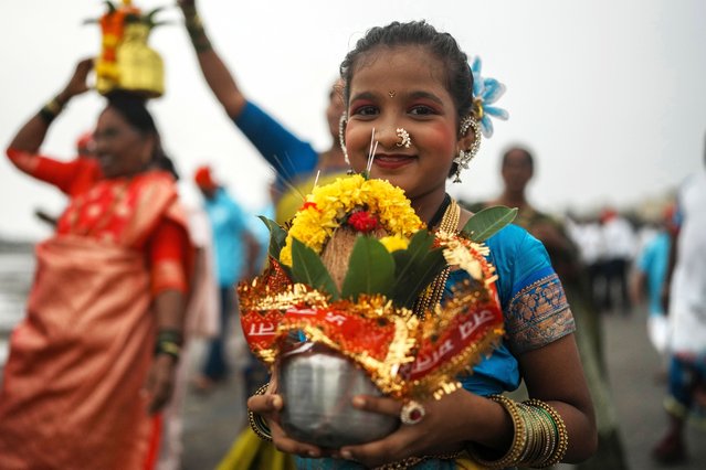 A girl from a fishing community arrives to offer coconuts to the ocean to celebrate Narali Pournima, or coconut festival, in Mumbai, India, Monday, August 19, 2024. (Photo by Rafiq Maqbool/AP Photo)