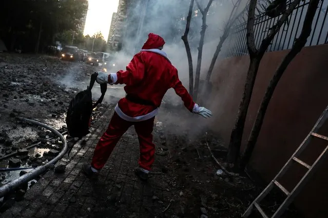 A demonstrator in Santa Claus outfit reacts during a protest against Chile's government in Santiago, Chile, December 13, 2019. (Photo by Ivan Alvarado/Reuters)