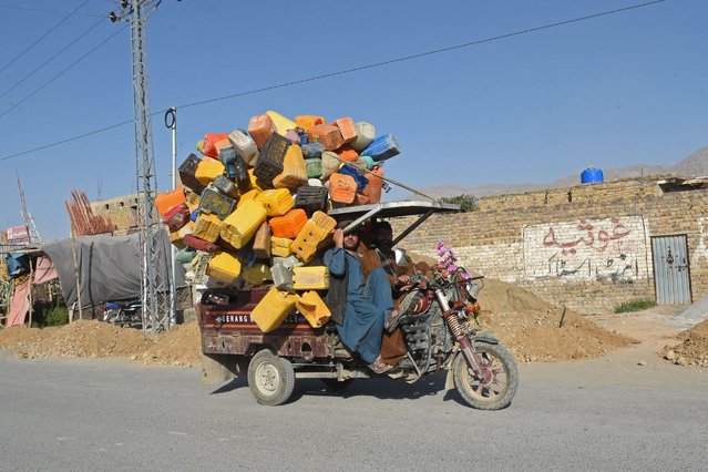 Workers transport plastic containers on a vehicle along a street in Quetta on September 8, 2024. (Photo by Banaras Khan/AFP Photo)