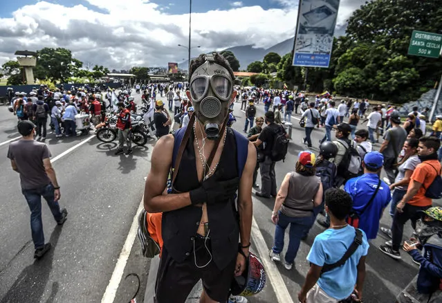 Opposition activistS rally to protest against the government of President Nicolas Maduro, at the Francisco Fajardo highway in Caracas, on July 1, 2017. Venezuela marks three months of violent protests within a political and economic crisis with protesters demanding President Nicolas Maduro' s resignation and new elections. (Photo by Juan Barreto/AFP Photo)