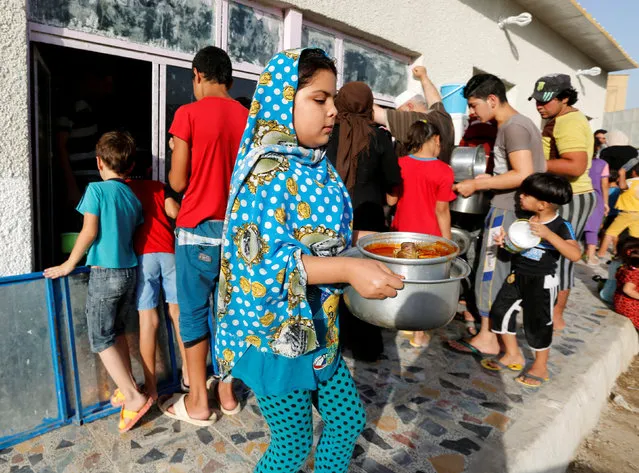 Displaced people, who fled from Islamic State violence, and the needy receive free food distributed during the fasting month of Ramadan at a restaurant in Baghdad, Iraq, June 22, 2016. (Photo by Ahmed Saad/Reuters)
