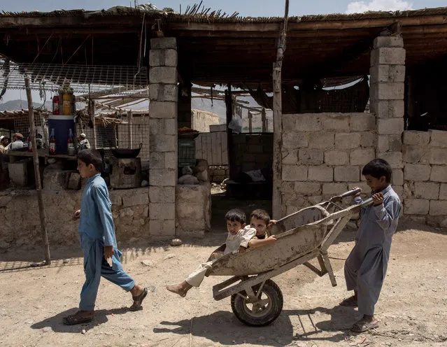Children play with a wheel barrow on July 15, 2017 in Shadal Bazaar, Afghanistan. (Photo by Andrew Renneisen/Getty Images)