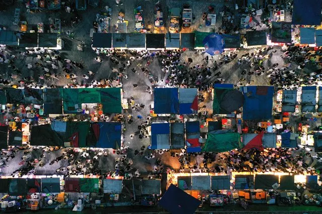 This aerial photo taken on June 11, 2022 shows people visiting a night market in Nanjing in China's eastern Jiangsu province. (Photo by AFP Photo/China Stringer Network)