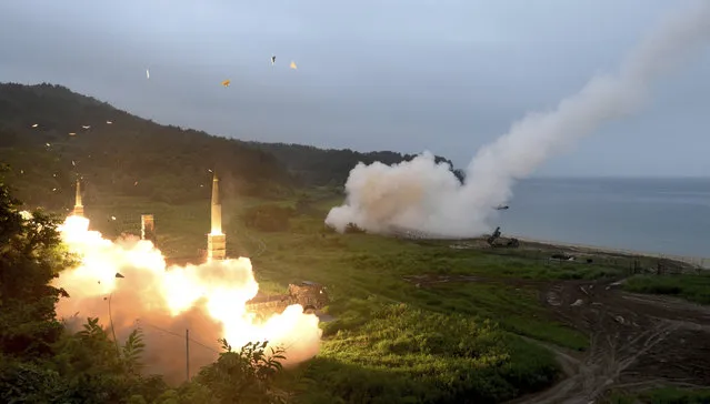 In this photo provided by South Korea Defense Ministry, South Korea's Hyunmoo II Missile system, left, and U.S. Army Tactical Missile System, right, fire missiles during the combined military exercise between the two countries against North Korea at an undisclosed location in South Korea, Saturday, July 29, 2017. North Korean leader Kim Jong Un said Saturday the second flight test of an intercontinental ballistic missile demonstrated his country can hit the U.S. mainland, hours after the launch left analysts concluding that a wide swath of the United States, including Los Angeles and Chicago, is now in range of North Korean weapons. (Photo by South Korea Defense Ministry via AP Photo)