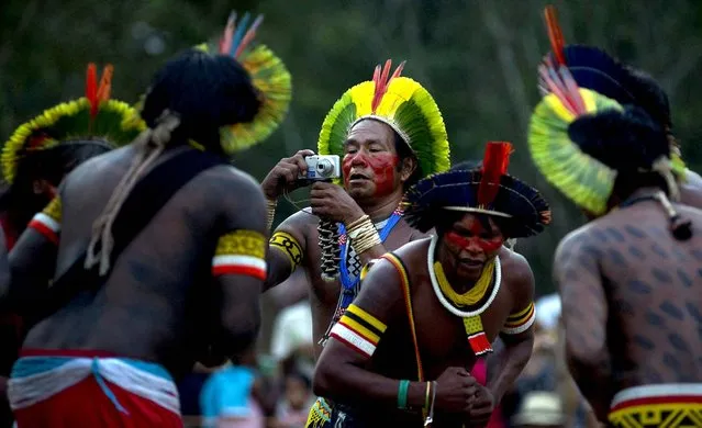 A Kaiapo Indian takes pictures of fellow tribesmen during an exhibition of their traditional games at Kari-Oca village, where indigenous groups are staying during the Rio+20 United Nations Conference on Sustainable Development in Rio de Janeiro, Brazil on June 17, 2012