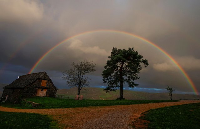 A rainbow shines in the sky over the La Bessayrie hamlet at sunset near Conques, south of France on April 9, 2024. (Photo by Gonzalo Fuentes/Reuters)