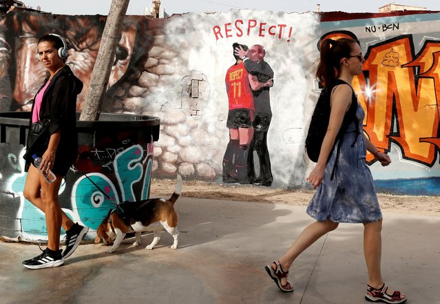 Women walk past a mural depicting the controversy over a kiss of Spanish FA chief Luis Rubiales to player Jenni Hermoso during World Cup celebrations, on a wall at Glories Park in Barcelona, Spain on September 4, 2023. (Photo by Bruna Casas/Reuters)