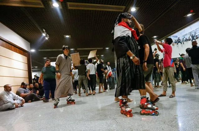 Supporters of Iraqi Shi'ite cleric Moqtada al-Sadr in roller skates attend a protest against corruption, inside the Parliament, in Baghdad, Iraq on July 30, 2022. (Photo by Ahmed Saad/Reuters)