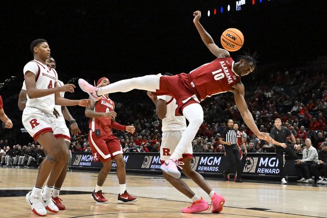 Alabama forward Mouhamed Dioubate (10) falls to the court after being fouled by Rutgers during the second half of an NCAA college basketball game Wednesday, November 27, 2024, in Las Vegas. (Photo by David Becker/AP Photo)