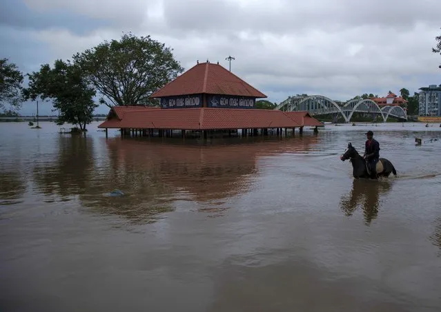 A youth rides a horse past a partially submerged Hindu temple through the waters of River Periyar which flooded due to heavy rains in Kochi, Kerala state, India, Tuesday, August 2, 2022. (Photo by R.S. Iyer/AP Photo)
