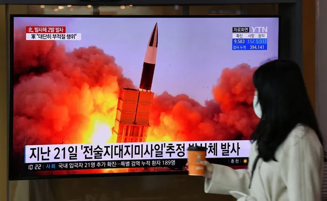 A woman walks past a screen showing file footage of a North Korean missile test, at a railway station in Seoul on March 29, 2020. North Korea fired what appeared to be two short-range ballistic missiles off its east coast on March 29, the fourth such launch this month as the world battles the coronavirus pandemic. (Photo by Jung Yeon-je/AFP Photo)