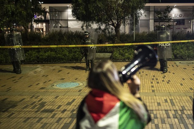 A woman shouts on a bullhorn during a protest in front of the Israeli embassy to show support for the Palestinian people in the latest Israel-Hamas war, in Bogota, Colombia, Thursday, October 19, 2023. (Photo by Ivan Valencia/AP Photo)