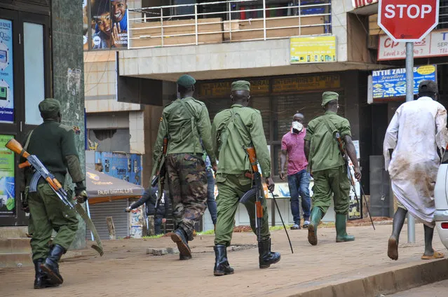 Ugandan police and other security forces chase people off the streets to avoid unrest, after police cleared a stand of motorcycle taxis which are no longer permitted to operate after all public transport was banned for two weeks to halt the spread of the new coronavirus, in Kampala, Uganda Thursday, March 26, 2020. (Photo by Ronald Kabuubi/AP Photo)