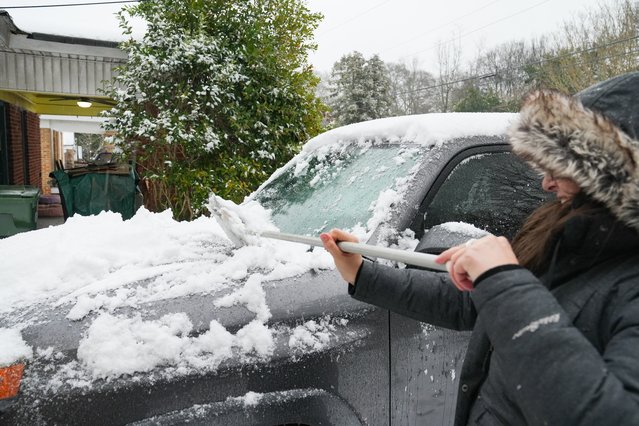 Atlanta resident Micaela Preston sweeps snow off her car on January 10, 2025 in Atlanta, Georgia. Atlanta has experienced a significant amount of snow but is bracing for the ice that is expected to follow. (Photo by Megan Varner/Getty Images)