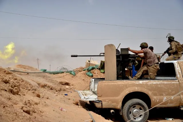 Shi'ite fighters fire weapons towards Islamic State militants on the outskirt of Baiji September 6, 2015. (Photo by Reuters/Stringer)