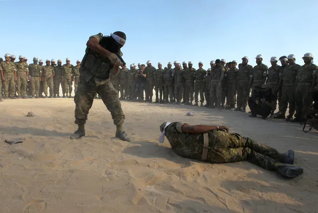 Fighters from Jaish al-Izzah, part of the Free Syrian Army, demonstrate their skills during a military display as part of a graduation ceremony at a camp in the Hama province, Syria July 29, 2016. (Photo by Ammar Abdullah/Reuters)