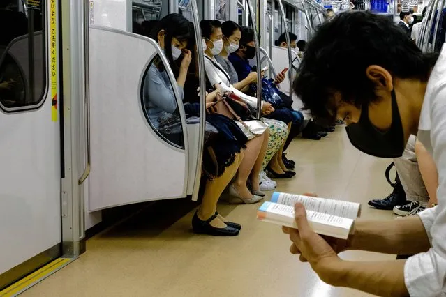 People wearing face masks, amid concerns of the COVID-19 coronavirus, travel on a train in Tokyo on May 25, 2020. (Photo by Philip Fong/AFP Photo)
