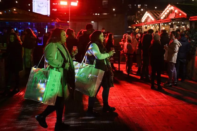 People enjoy refreshments at a Christmas market in Piccadilly Gardens in Manchester in north-west England on December 20, 2021. The UK Government on Monday faced pressure to tighten coronavirus restrictions to prevent the spread of the Omicron variant, despite opposition to do so before Christmas. (Photo by Oli Scarff/AFP Photo)