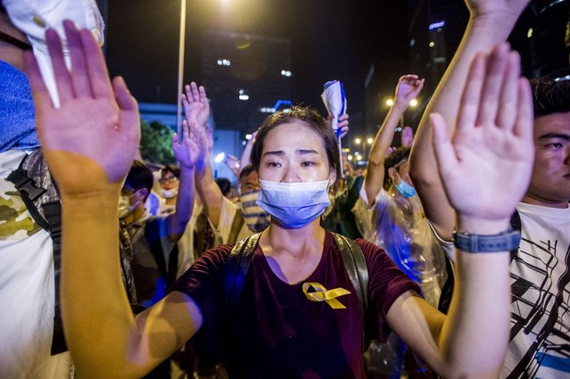 A demonstrator gestures opposite policemen during a pro-democracy protest in Hong Kong on September 28, 2014. Police fired tear gas as tens of thousands of pro-democracy demonstrators brought parts of central Hong Kong to a standstill in a dramatic escalation of protests that have gripped the semi-autonomous Chinese city for days. (Photo by Xaume Olleros/AFP Photo)