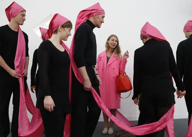 Sasha Burkhanova reacts to performers of artist James Lee Byers' artwork “Ten in a Hat”, a replica of the original 1968 version, at the Frieze Art Fair in London, October 14, 2014. (Photo by Luke MacGregor/Reuters)