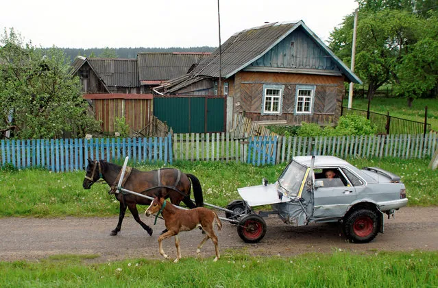 Belarusian shepherd Alexey Usikov, 33, drives a horse-drawn carriage, equipped with a battery, head lights, small potbelly stove, which he crafted out of an old Audi-80 calling it jokingly Audi-40 as he used only a half of the car, in the village of Knyazhytsy, Belarus on May 28, 2020. (Photo by Vasily Fedosenko/Reuters)