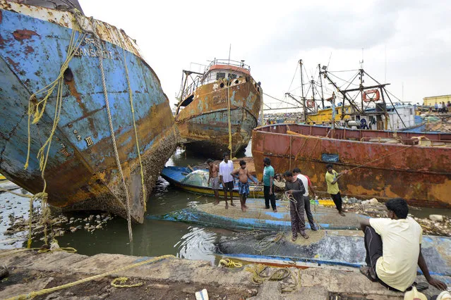 People stand on boats damaged by strong winds caused by Cyclone Hudhud in the southern Indian city of Visakhapatnam October 13, 2014. Cyclone Hudhud powered its way inland over eastern India on Monday, leaving a swathe of destruction but the loss of life appeared limited after tens of thousands of people sought safety in storm shelters, aid workers and officials said. (Photo by R. Narendra/Reuters)
