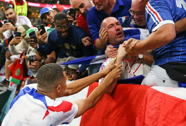 Kylian Mbappe of France goes to the French fan who is hit by the ball during the warm up before the FIFA World Cup Qatar 2022 semi final match between France and Morocco at Al Bayt Stadium on December 14, 2022 in Al Khor, Qatar. (Photo by Stefan Matzke – sampics/Corbis via Getty Images)