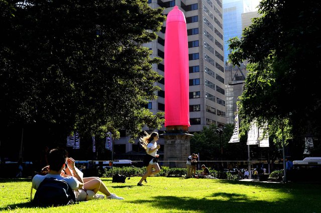 A gaint condom is seen over a heritage-listed obelisk at Hyde Park in Sydney on November 7, 2014. An 18-metre (60-foot) bright pink condom raised eyebrows in Sydney after it was erected over a Sydney landmark as part of a new awareness campaign about HIV. (Photo by Saeed Khan/AFP Photo)