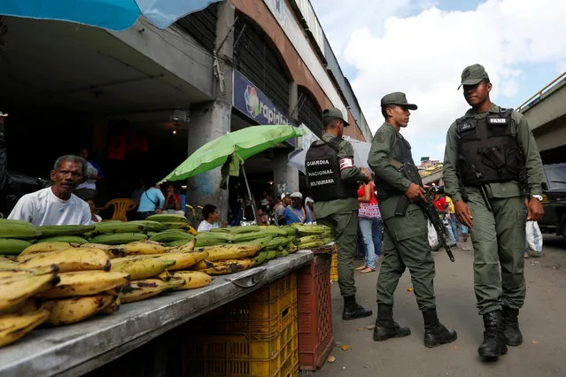 Members of the national guard are seen as they relocate street vendors during a routine patrol at the market in Petare neighborhood in Caracas, Venezuela July 14, 2016. (Photo by Carlos Jasso/Reuters)