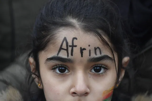 A young demonstrator with the word “Afrin” painted on his face takes part to a demonstration to protest against the ongoing Turkish military campaign in the Kurdish-held Syrian enclave of Afrin in front of the Turkish embassy in Berlin on January 26, 2018. Turkey launched an offensive against the Kurdish People's Protection Units (YPG) on January 20 in their enclave of Afrin, supporting Syrian rebels with air strikes and ground troops. (Photo by John MacDougall/AFP Photo)