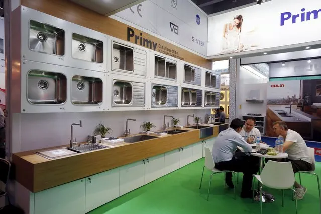 Foreign buyers have a discussion with an exhibitor at a booth selling kitchen and bathroom products during the China Import and Export Fair, also known as Canton Fair, in the southern Chinese city of Guangzhou October 15, 2015. (Photo by Bobby Yip/Reuters)