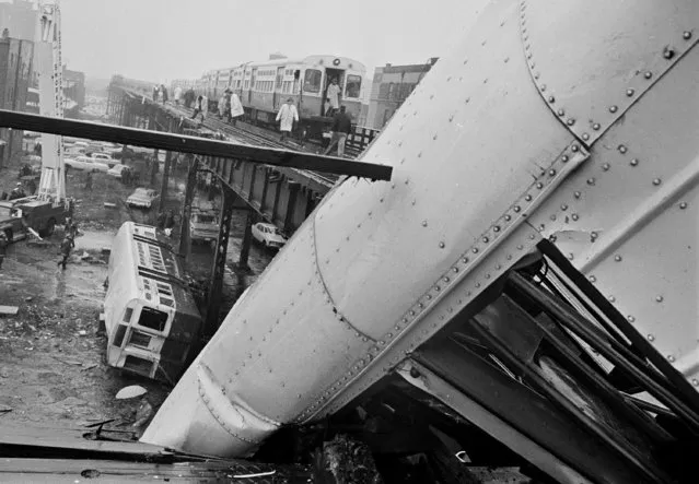 Rescue workers and a fire department snorkel work on the wreckage of an elevated train which derailed in Chicago, December 7, 1966. One car toppled 30 feet to the pavement and another car was left dangling, right.  The accident, on the city's South Side at 41st Street and Indiana Avenue, injured at least 25 people. (Photo by Charles E. Knoblock/AP Photo)
